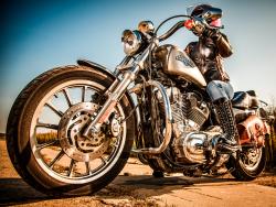 MOSCOW, RUSSIA-JULY 7, 2013: Biker girl on legendary bike Harley Sportster (focus on the wheel).Harley-Davidson sustains a large brand community which keeps active through clubs, events, and a museum. by Andrey Armyagov